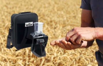 Landwirt prüft Getreide im Feld mit Feuchtigkeitsmessgerät – Symbol für Qualität und Erntekontrolle.