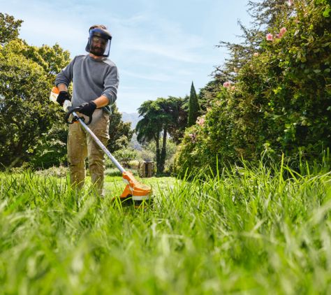 Mann bei der Gartenarbeit mit einem STIHL Freischneider.