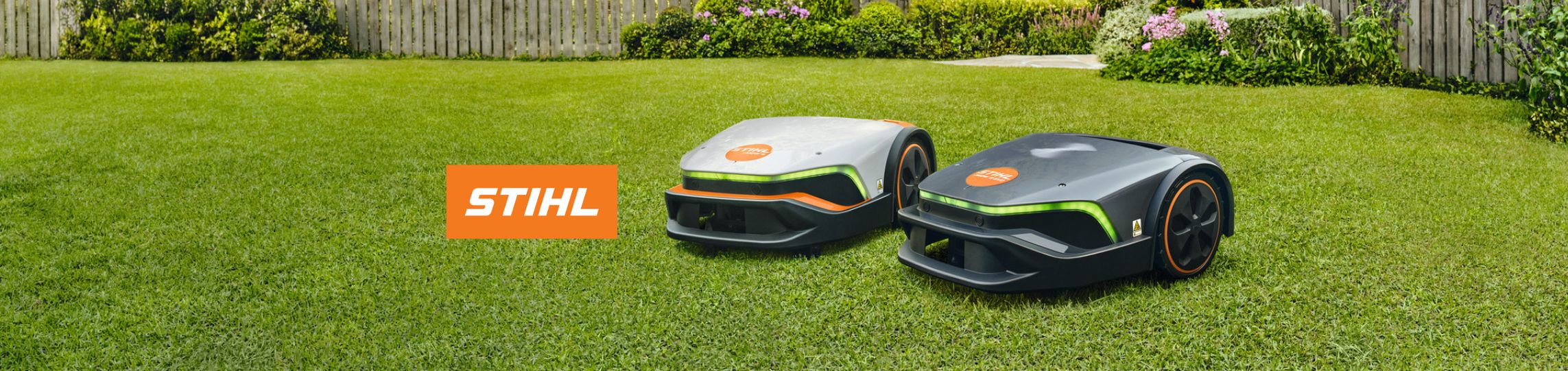 STIHL iMow und iMow EVO Mähroboter nebeneinander auf Rasenfläche