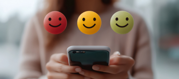 Illustration mit drei Smiley-Symbolen in Rot, Gelb und Grün für eine Umfrage-Bewertung; darunter Hände, die ein Smartphone halten.