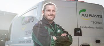 Mitarbeiter steht vor einem Service-Fahrzeug.