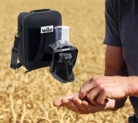 Landwirt prüft Getreide im Feld mit Feuchtigkeitsmessgerät – Symbol für Qualität und Erntekontrolle.