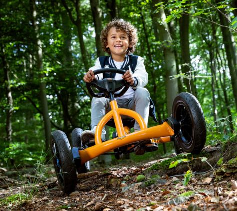 Junge fährt im Wald mit einem BERG Gokart über einen naturbelassenen Weg